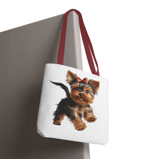 Compact Yorkie puppy tote bag with cheerful red bow and white background, available in three sizes.