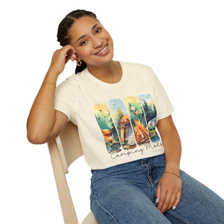 Woman wearing a cream Camping Adventure Unisex T-Shirt with colorful nature and camping graphics sitting on a chair