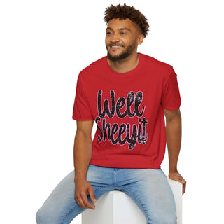 Man wearing red casual statement tee with "Well Sheeyit!" text sitting on white block