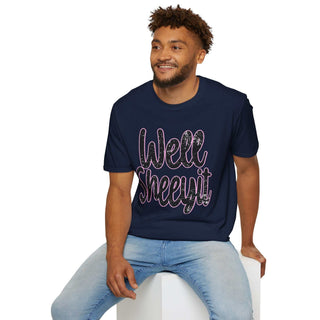 Man wearing navy blue casual statement tee with "Well Sheeyit!" text sitting on white block