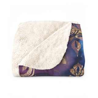 Luxurious gold damask sherpa blanket with deep indigo and violet hues, plush fleece, and durable hemmed edges.