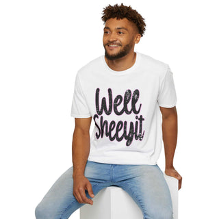 Man wearing white casual statement tee with "Well Sheeyit!" text and blue jeans sitting on white cube against white background